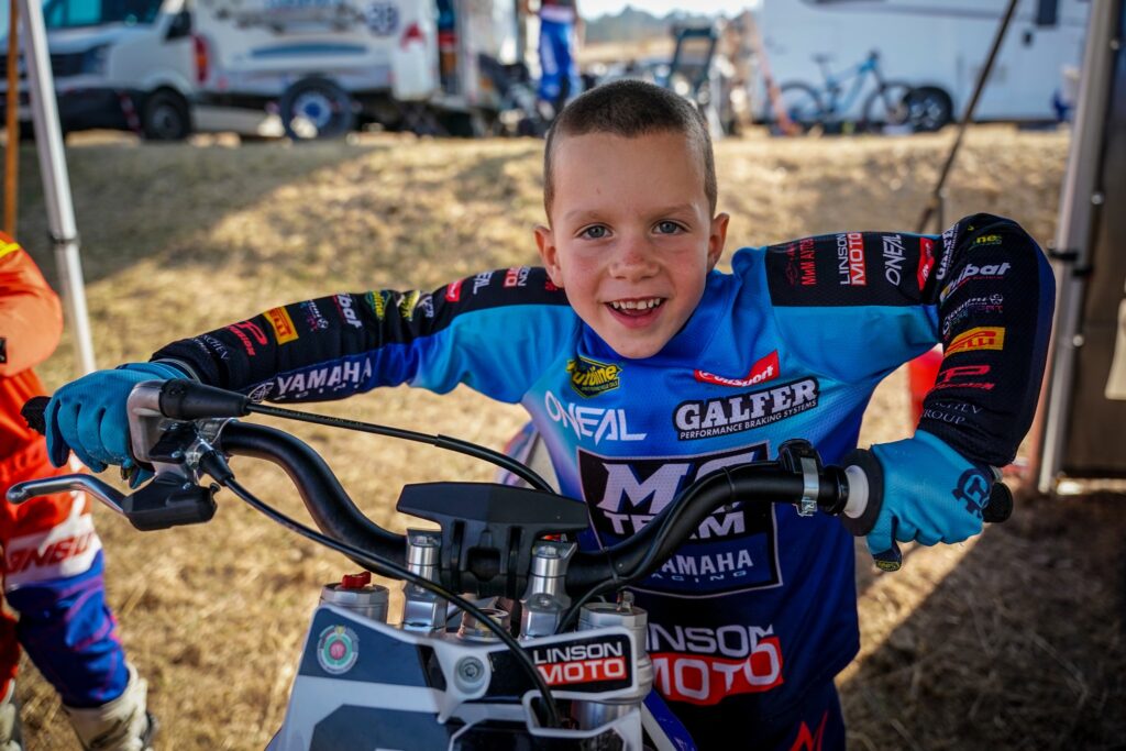 Radi smiles in the paddock, sitting on his bike